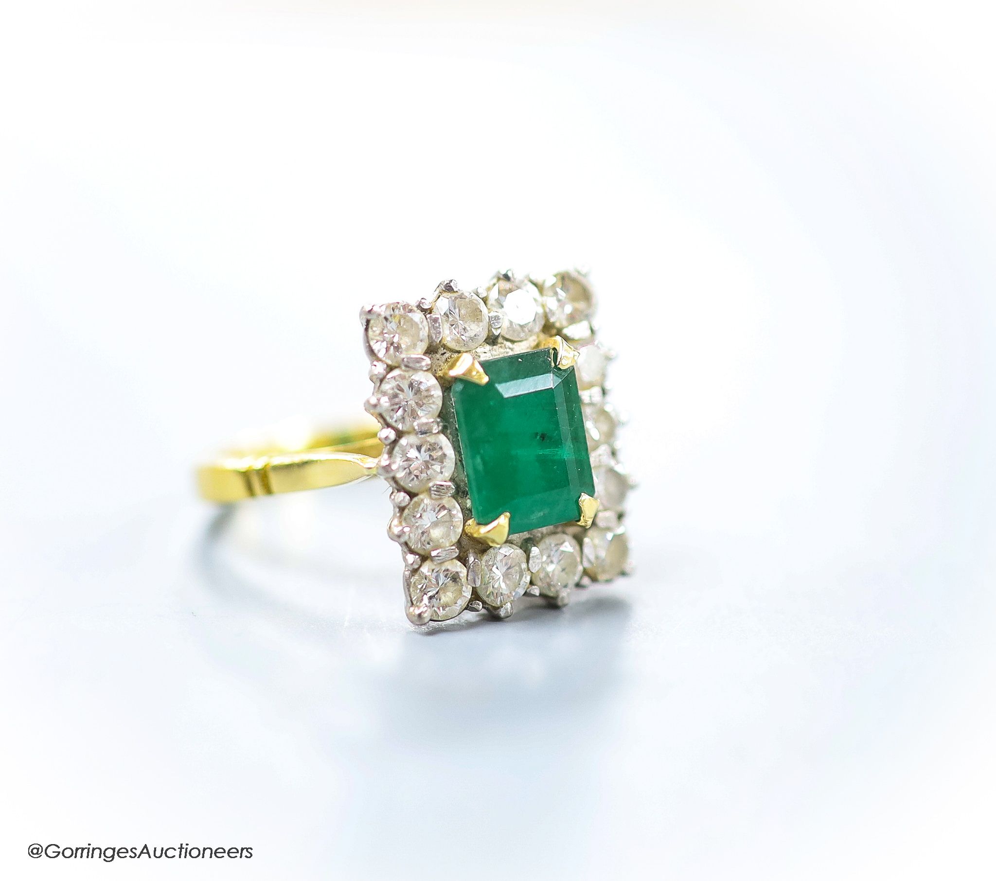 A modern 18ct gold, emerald and diamond set rectangular cluster ring, size K